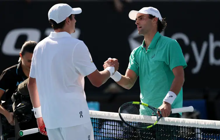 Tennis - Australian Open - Melbourne Park, Melbourne, Australia - January 20, 2026 Eliot Spizzirri of the U.S. shakes hands with Brazil's Joao Fonseca after winning his first round match REUTERS/Edgar Su